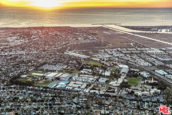 an aerial view of ocean and residential houses with outdoor space