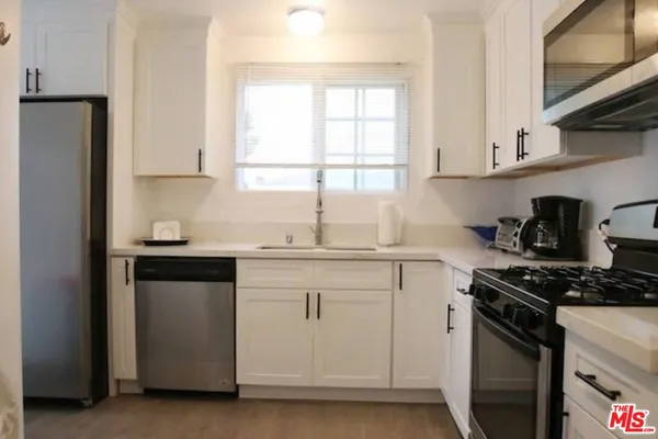 a kitchen with granite countertop white cabinets and white appliances