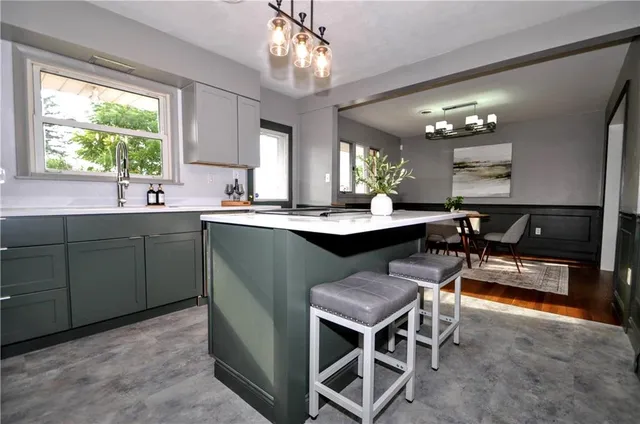 a kitchen with a table chairs sink and cabinets