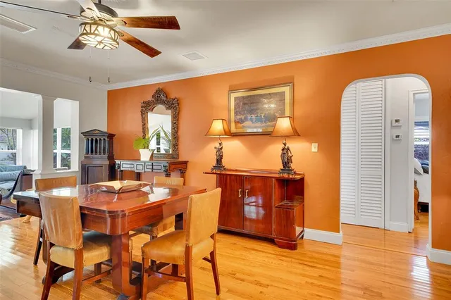 a kitchen with stainless steel appliances granite countertop a refrigerator a sink dishwasher a stove and a dining table with wooden floor