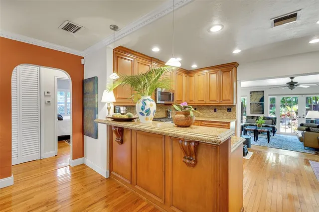 a living room with furniture kitchen view and a chandelier