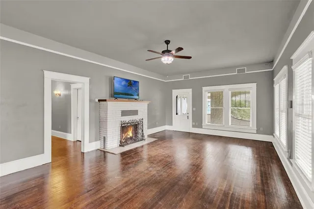 a view of an empty room with a fireplace and a window