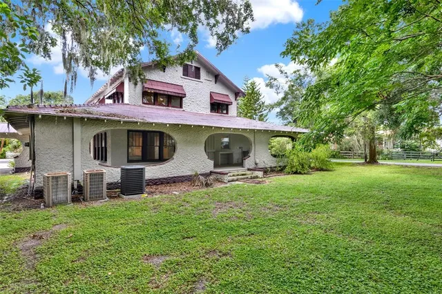 a view of a house with a yard and sitting area