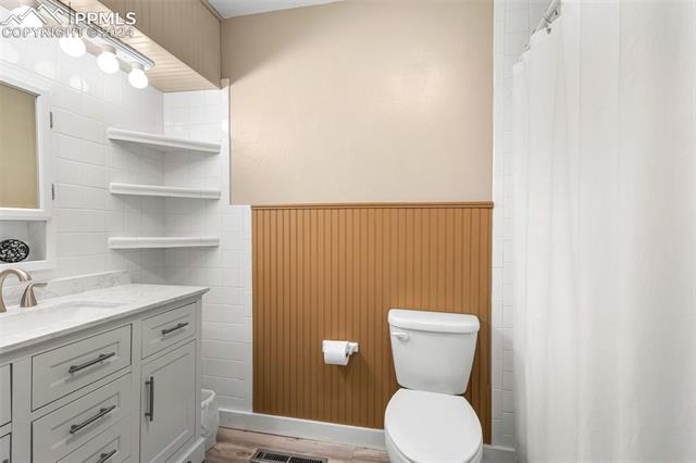 2125 Winston Road Colorado Springs, CO 80909 - Photo 18 of 37 Bathroom with toilet, hardwood / wood-style flooring, and oversized vanity