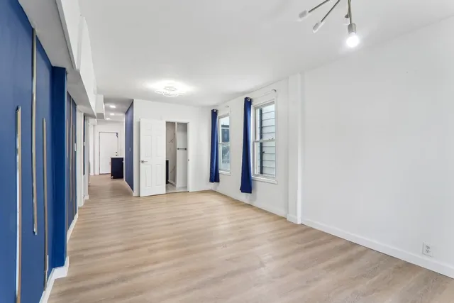 a view of an empty room with closet and a window