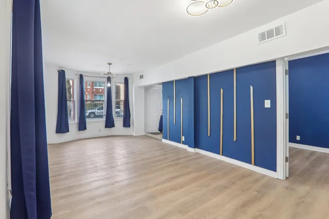 a view of a livingroom with an entryway and wooden floor
