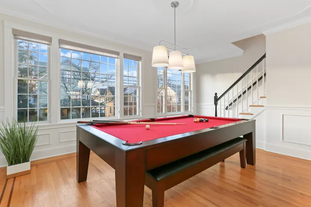 a room with pool table windows and wooden floor