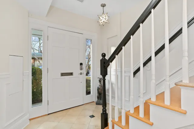 a view of staircase with lots of frames on wall and a chandelier