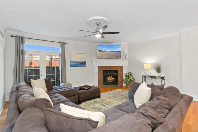 a living room with furniture a large window and a fireplace