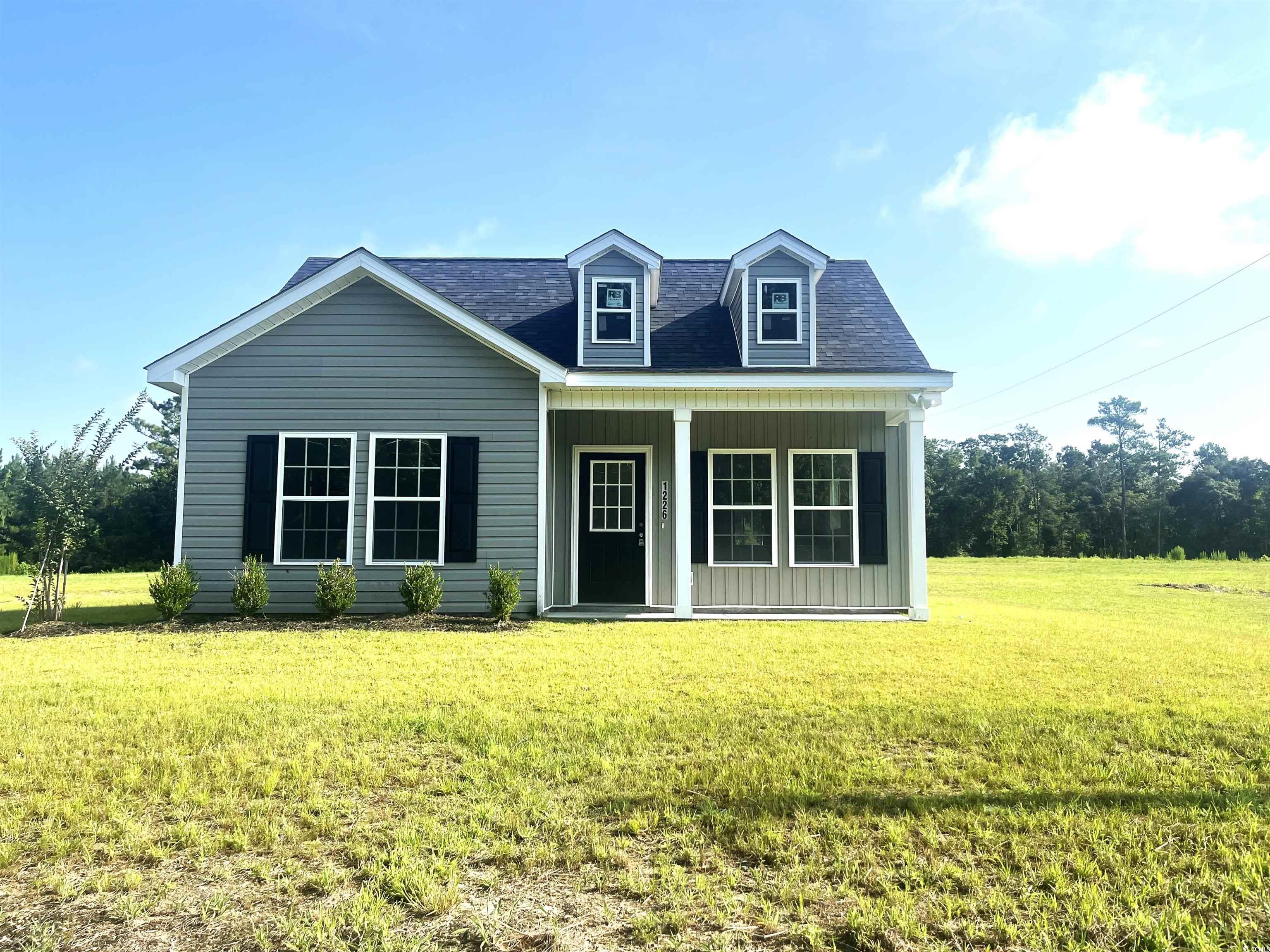 1226 St John Road Galivants Ferry, SC 29544 - Photo 1 of 21 View of front of property featuring board and batten siding, a front yard, a porch, and roof with shingles
