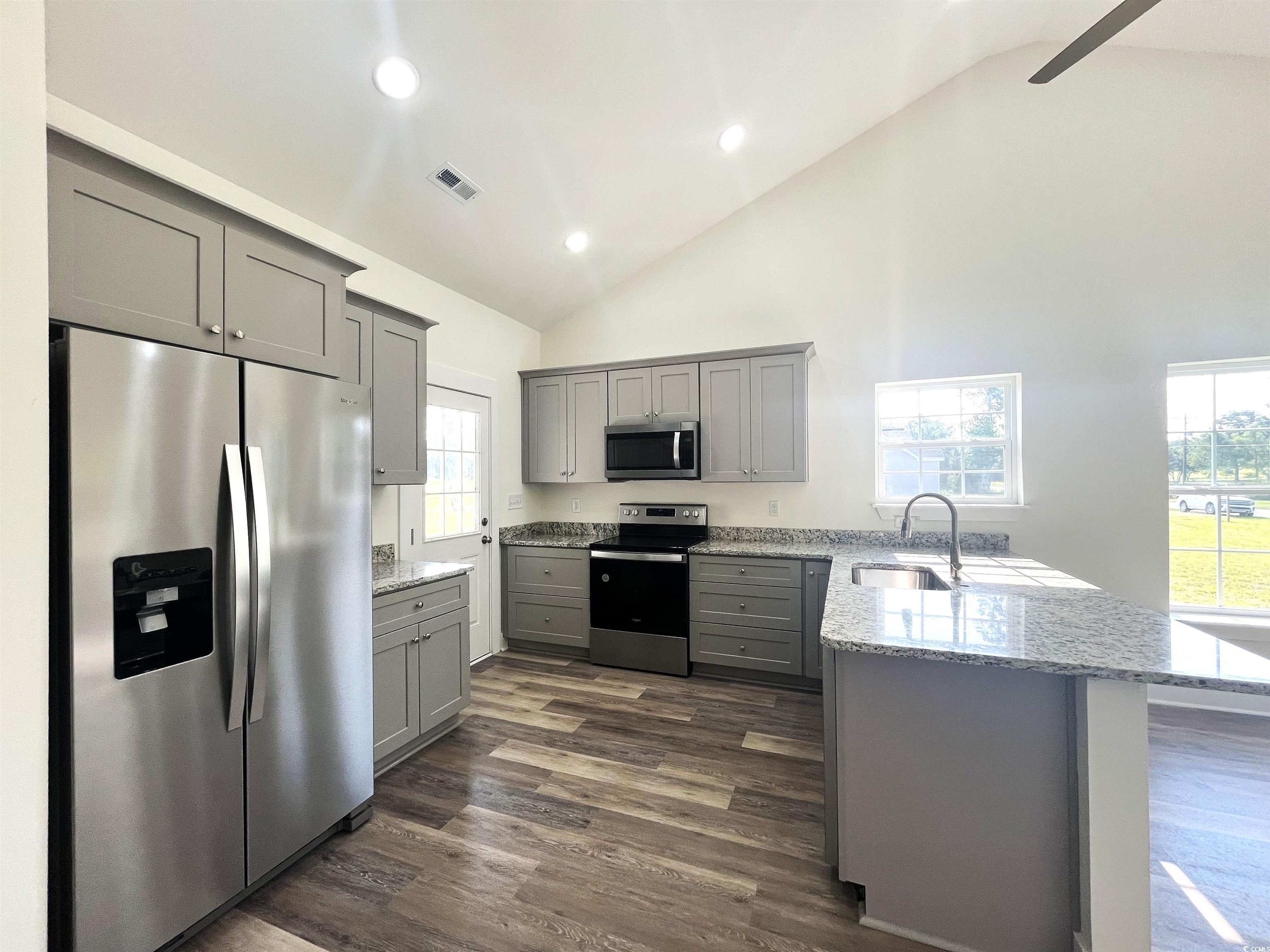 1226 St John Road Galivants Ferry, SC 29544 - Photo 5 of 21 Kitchen with stainless steel appliances, gray cabinetry, a peninsula, light stone countertops, and dark wood-type flooring