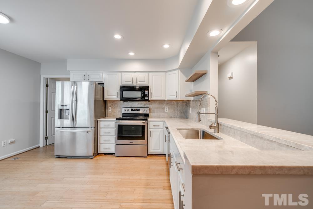 2349 Florida Court Raleigh, NC 27615 - Photo 4 of 19 a kitchen with a sink stainless steel appliances and white cabinets