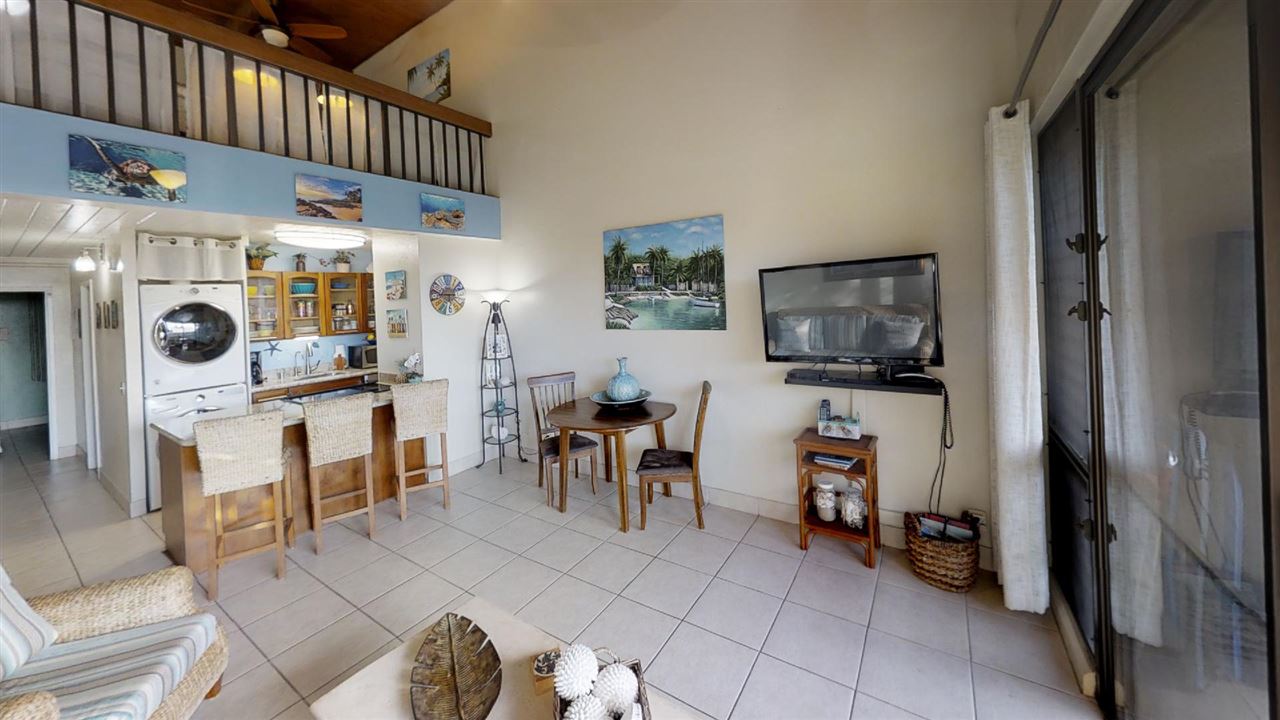 2191 South Kihei Road, Unit 3419 Kihei, HI 96753 - Photo 21 of 30 a living room with furniture a flat screen tv and a refrigerator