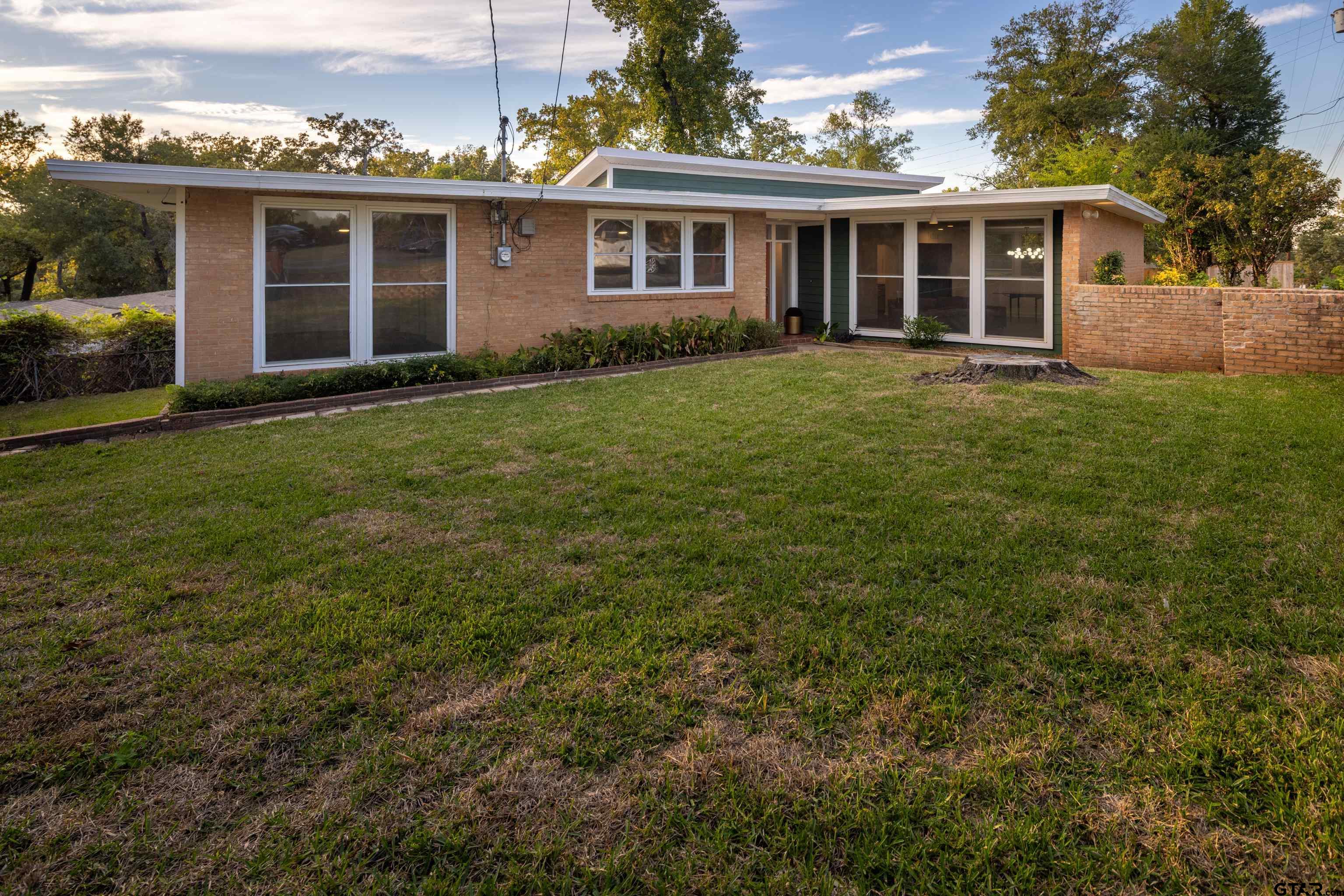 1715 Ridgeview Drive Tyler, TX 75701 - Photo 1 of 35 a view of a yard in front of a house with large windows