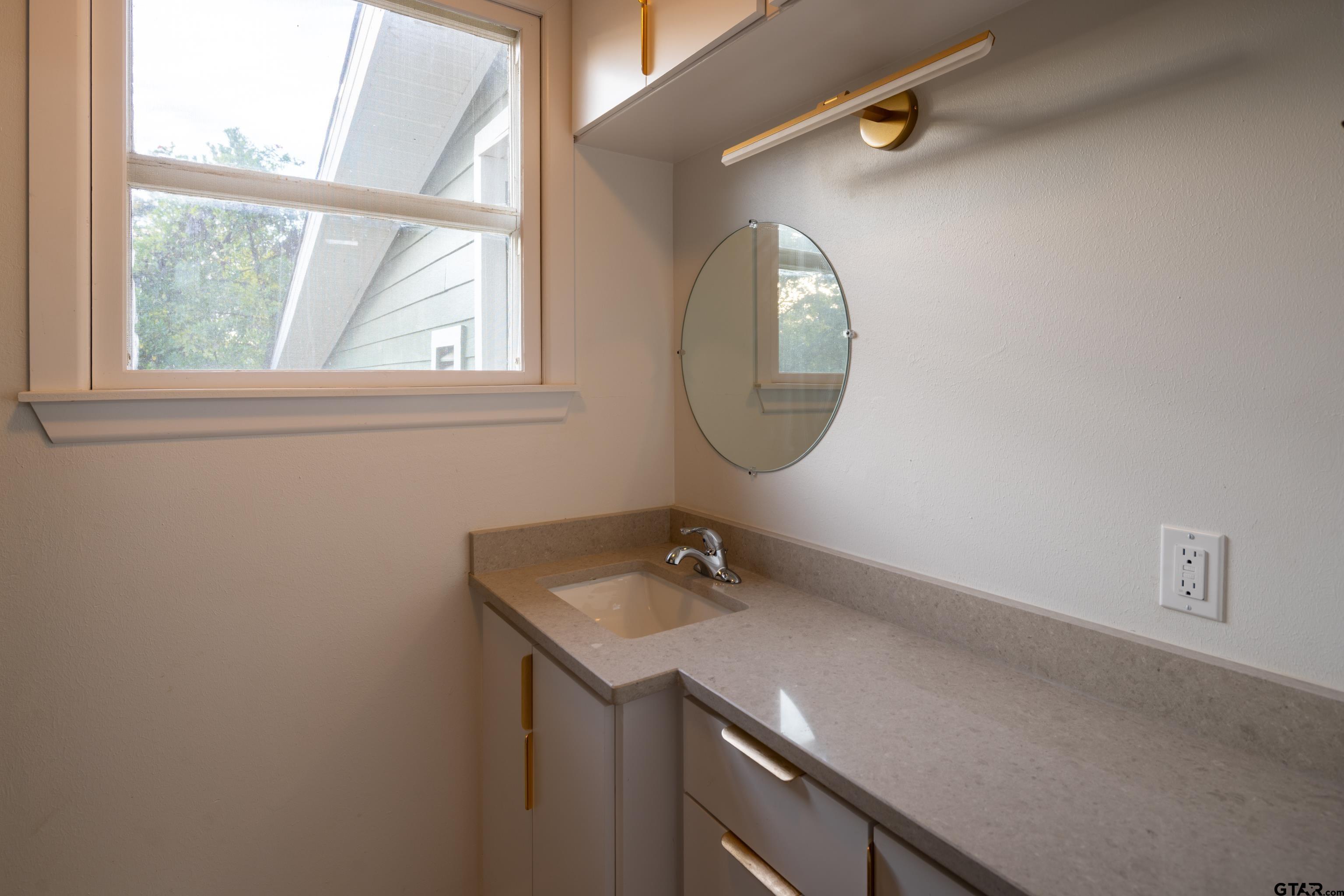 1715 Ridgeview Drive Tyler, TX 75701 - Photo 18 of 35 a bathroom with a sink a vanity and a mirror