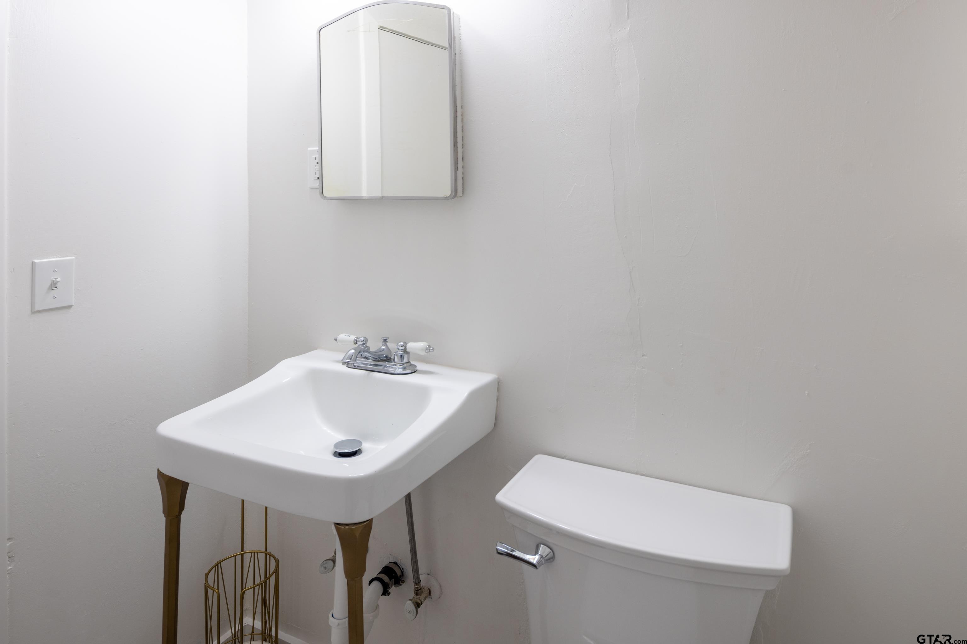 1715 Ridgeview Drive Tyler, TX 75701 - Photo 22 of 35 a bathroom with a sink a mirror and a toilet