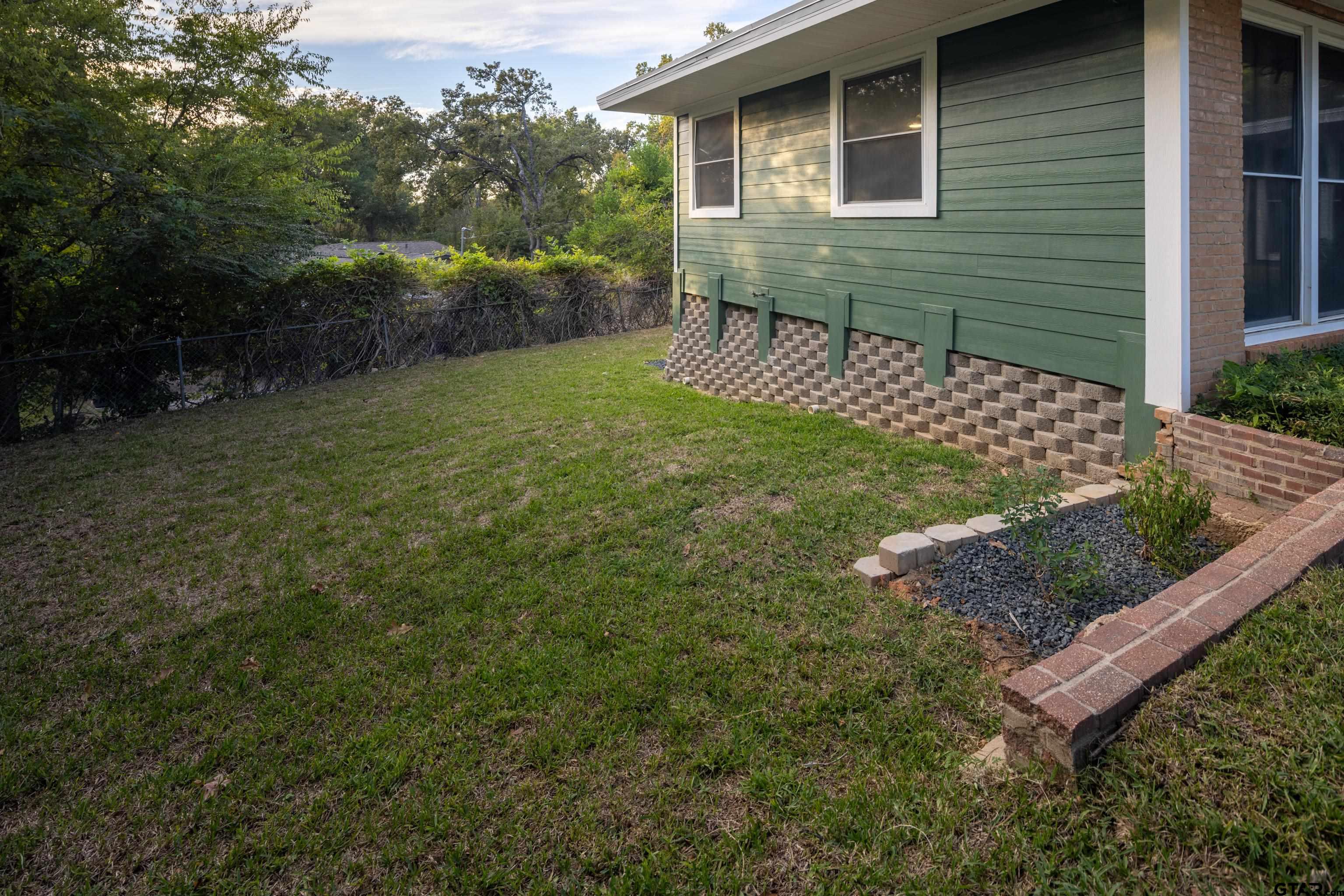 1715 Ridgeview Drive Tyler, TX 75701 - Photo 25 of 35 a view of a backyard with couches under an umbrella