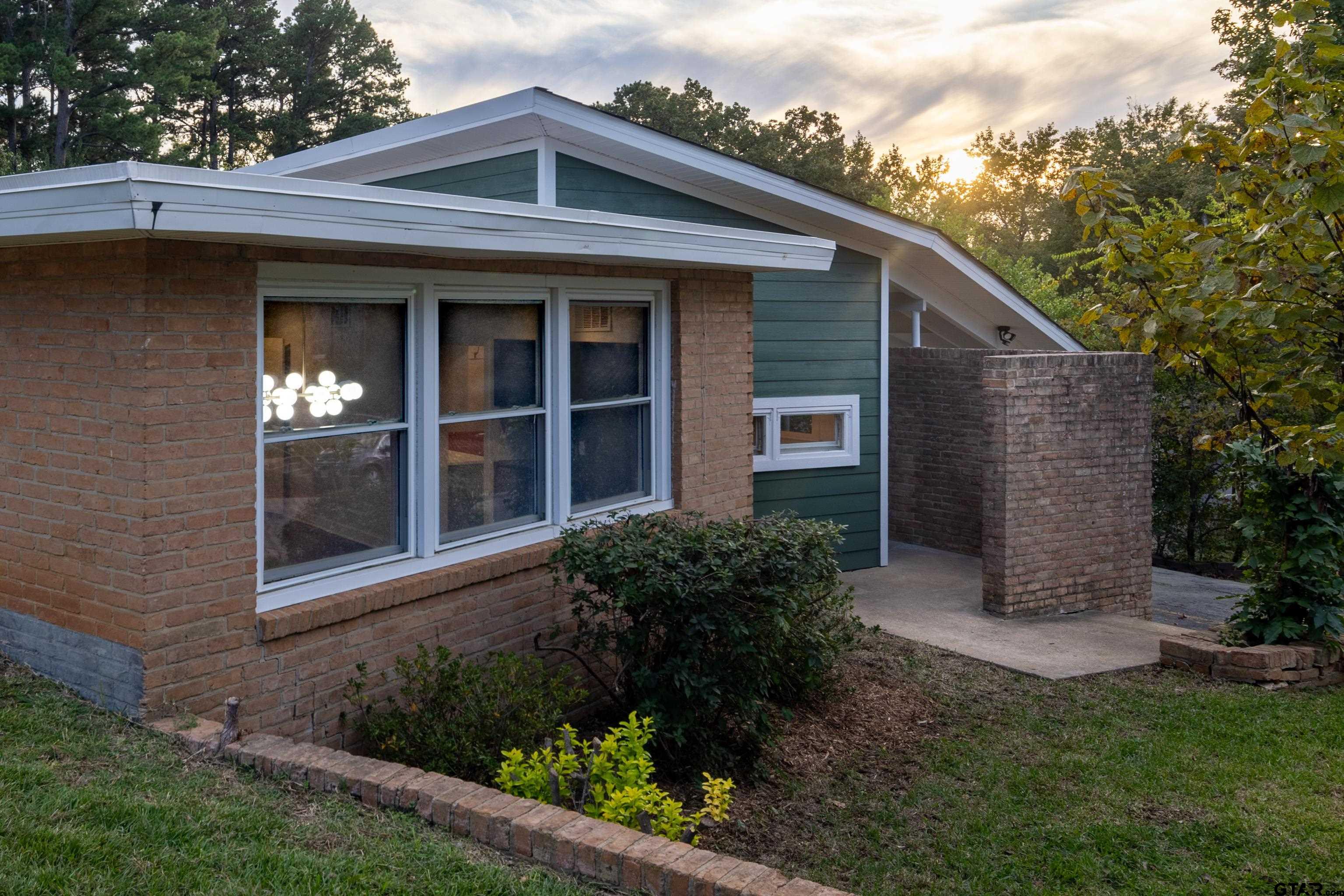 1715 Ridgeview Drive Tyler, TX 75701 - Photo 26 of 35 a view of a brick house with a large windows and flower plants