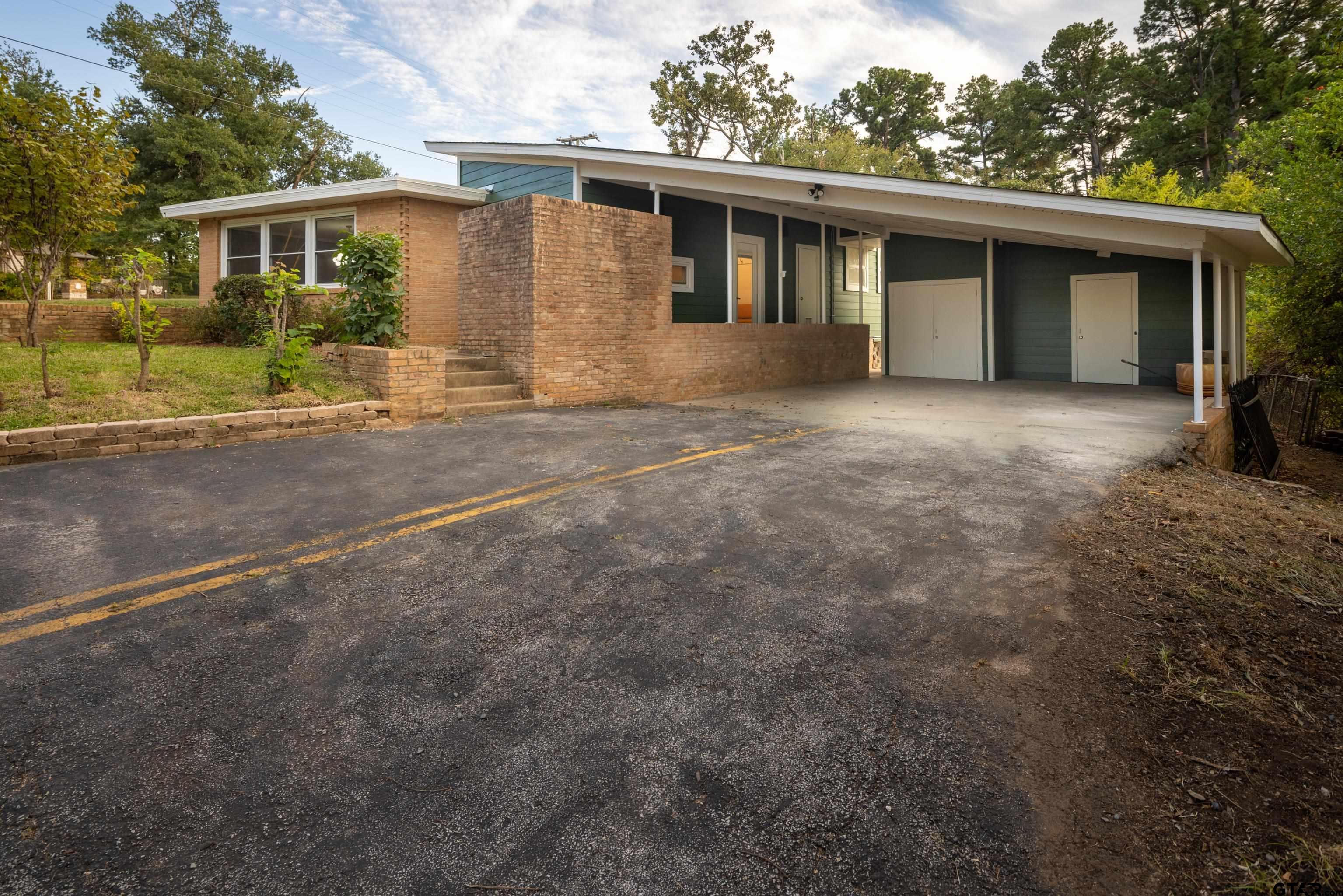 1715 Ridgeview Drive Tyler, TX 75701 - Photo 29 of 35 a front view of a house with a yard and garage