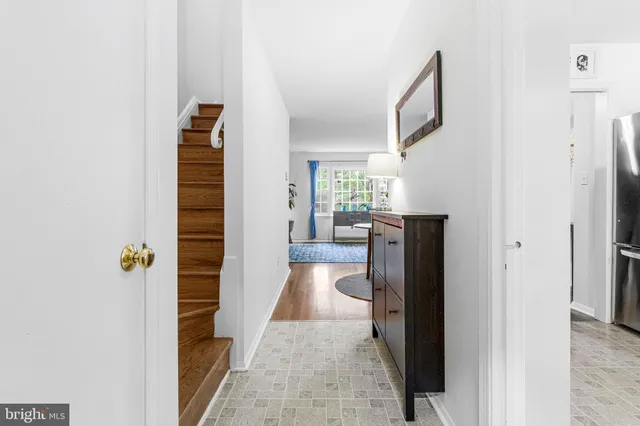 a view of a hallway with wooden floor and a living room