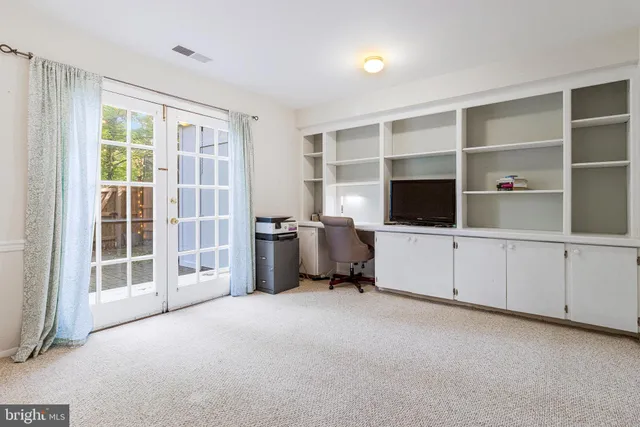 a view of a bedroom with workspace and windows