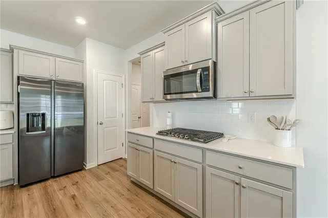 a kitchen with stainless steel appliances granite countertop a refrigerator stove and sink