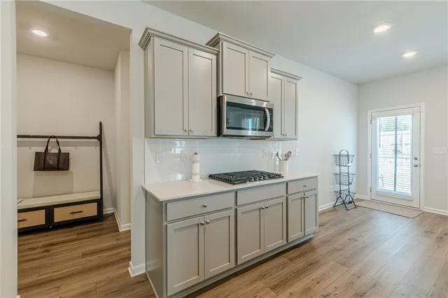a kitchen with stainless steel appliances granite countertop a stove a sink and a microwave