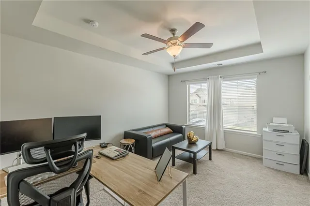 a view of a workspace with furniture and a window