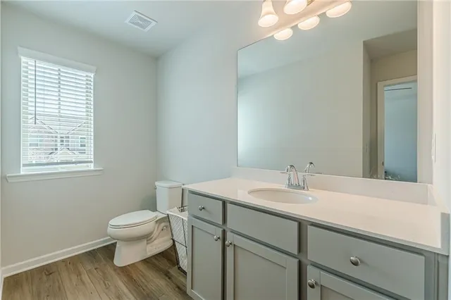 a bathroom with a sink a toilet and a mirror