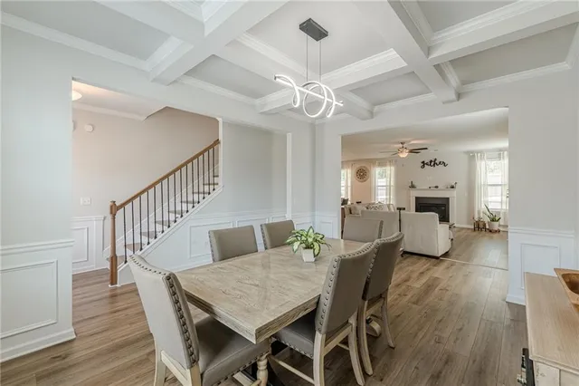 a dining room with furniture a chandelier and wooden floor