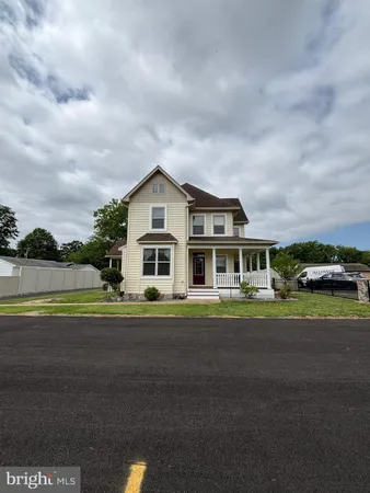 a front view of a house with a yard and road