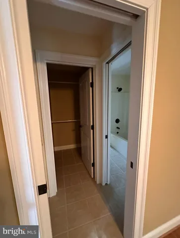 a view of a hallway with a ceiling fan and wooden floor