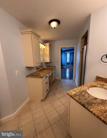 a kitchen with granite countertop a sink cabinets and stainless steel appliances