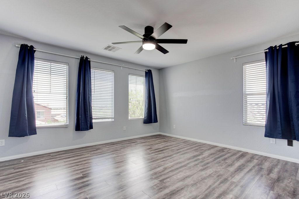 7724 Vibrant Thread Court Las Vegas, NV 89149 - Photo 20 of 43 A naturally illuminated room features light flooring, multiple windows, and a ceiling fan for year-round comfort.