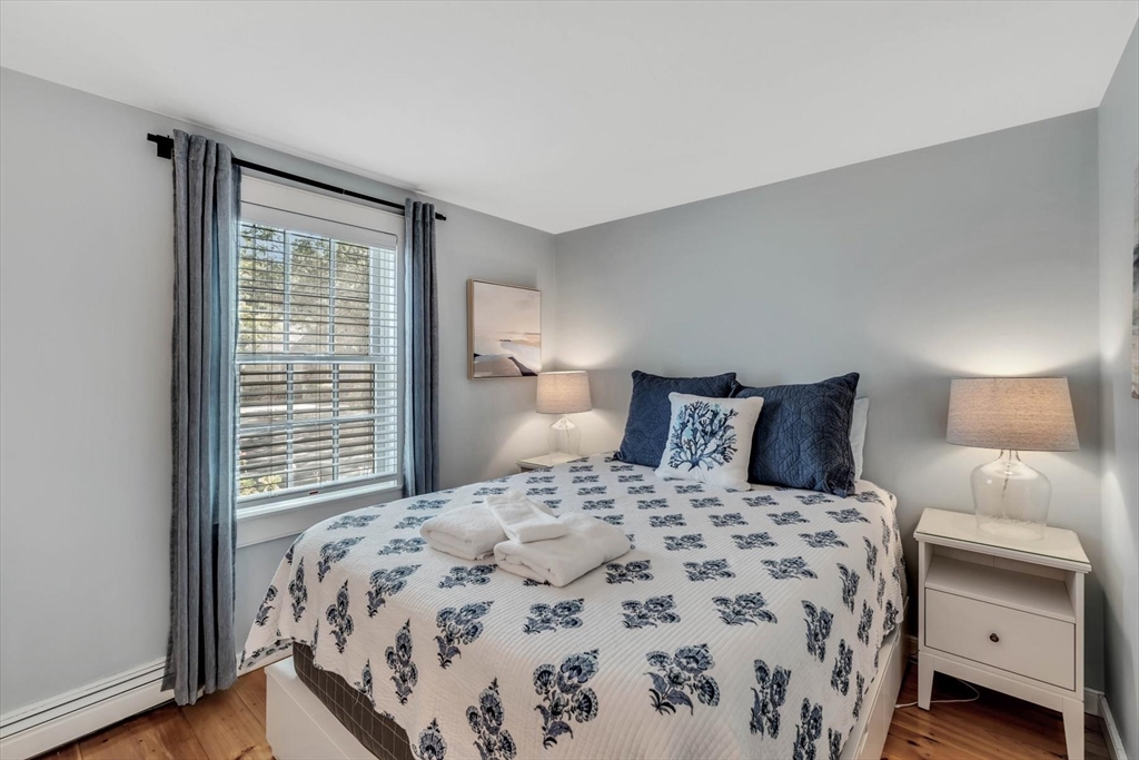 36 Brant Rock Road, Unit 821 Mashpee, MA 02649 - Photo 12 of 23 a bedroom with a bed and a lamp