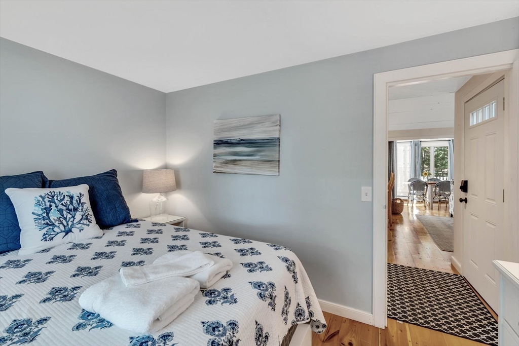 36 Brant Rock Road, Unit 821 Mashpee, MA 02649 - Photo 14 of 23 a bedroom with a large bed and wooden floor