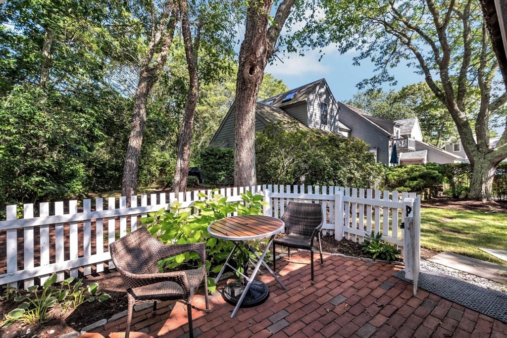 36 Brant Rock Road, Unit 821 Mashpee, MA 02649 - Photo 4 of 23 a view of a chairs and table in backyard