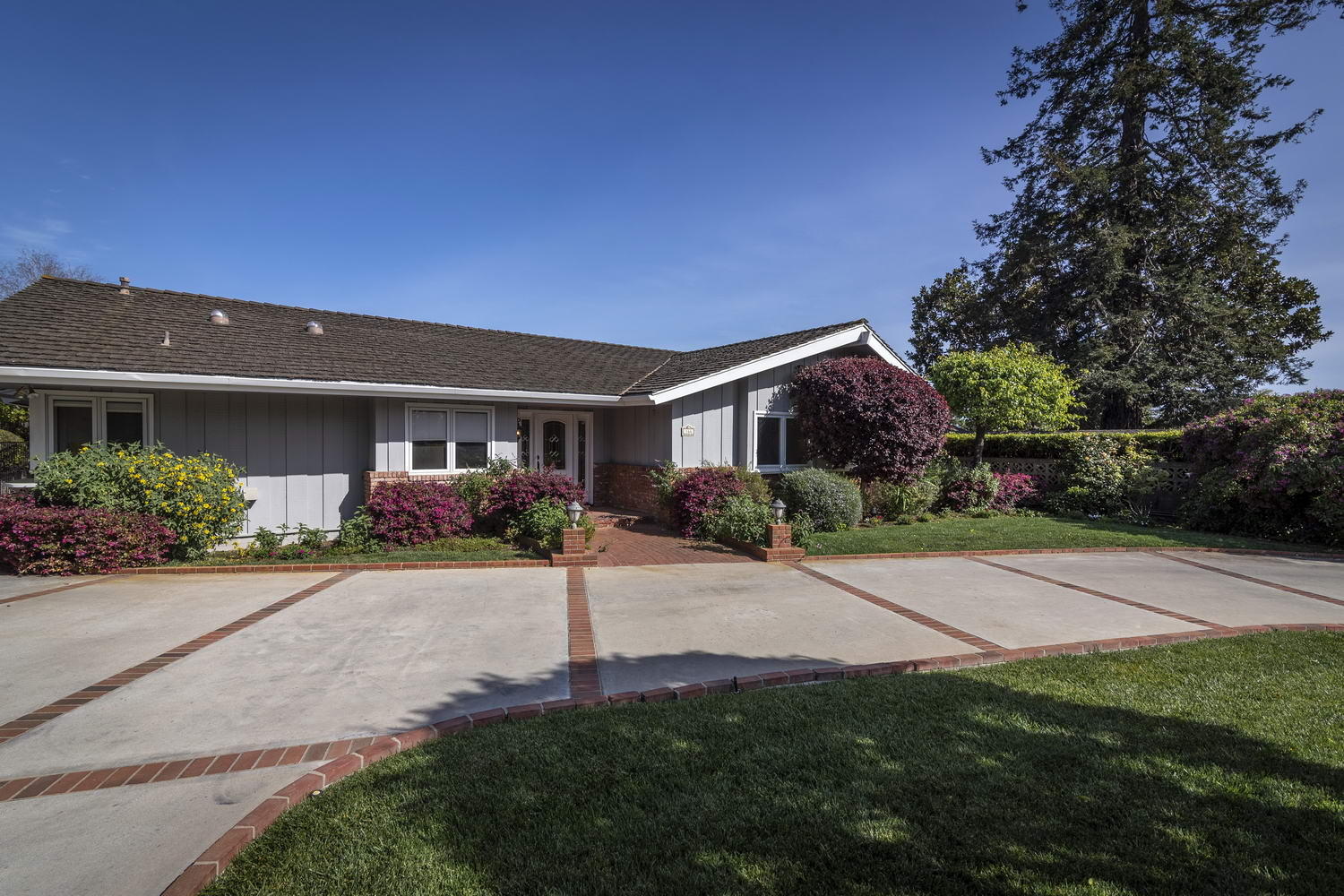 166 Toro Canyon Road Carpinteria, CA 93013 - Photo 3 of 11 a front view of a house with a yard and a garage