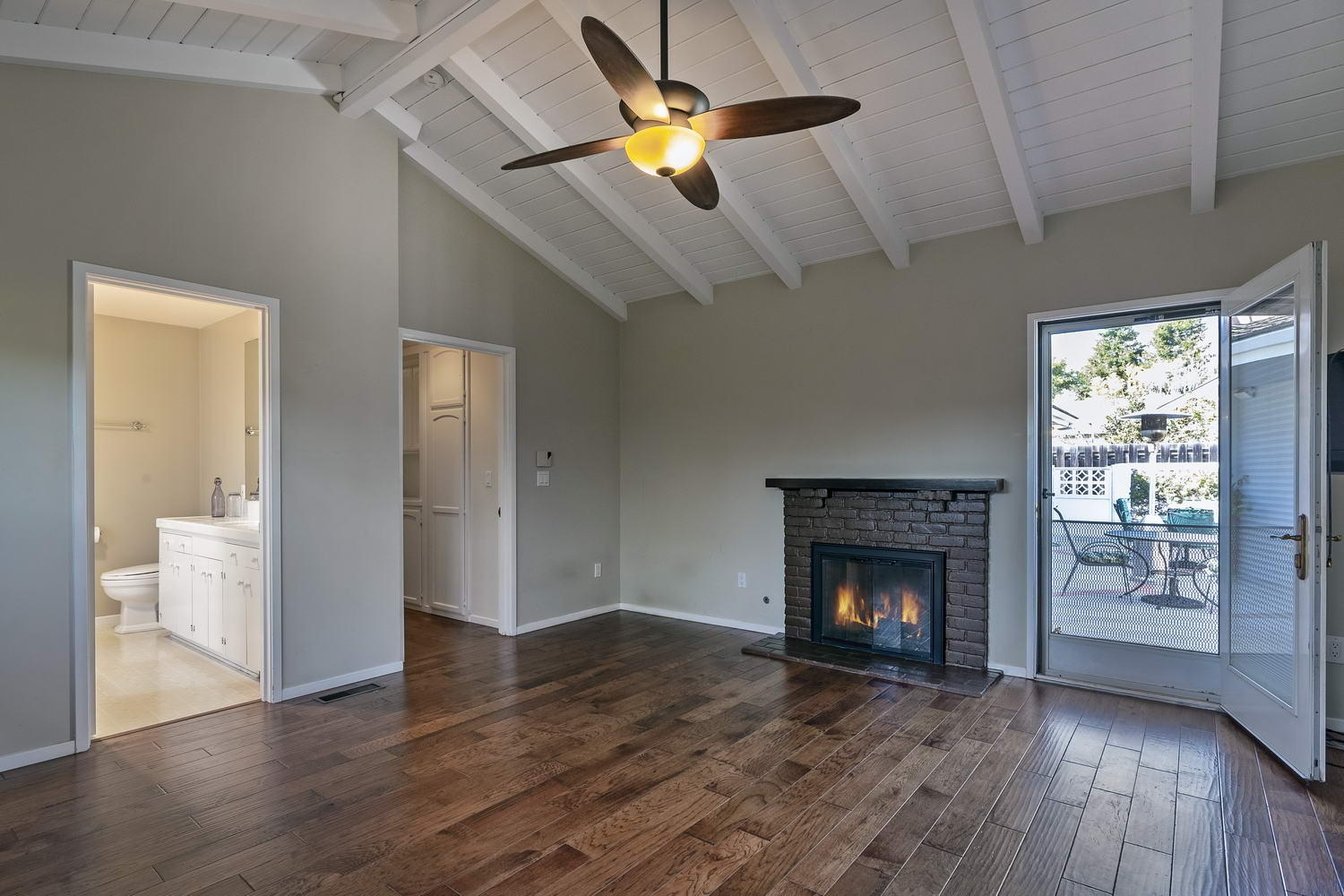 166 Toro Canyon Road Carpinteria, CA 93013 - Photo 7 of 11 a view of an empty room with wooden floor fireplace and a window