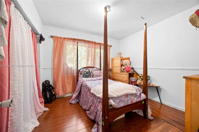 a bedroom with a bed and a flat tv screen on dresser