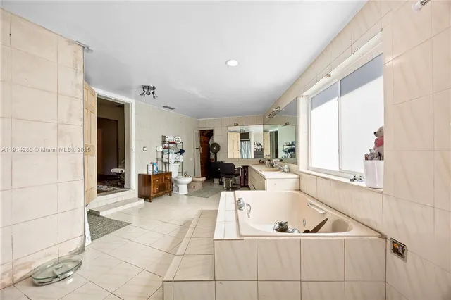 a large white kitchen with sink and cabinets