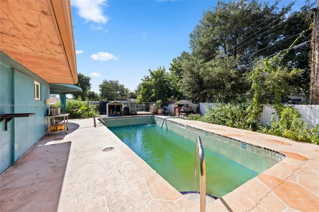 a view of a house with swimming pool and a yard