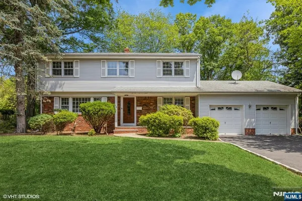 a front view of a house with a yard and potted plants