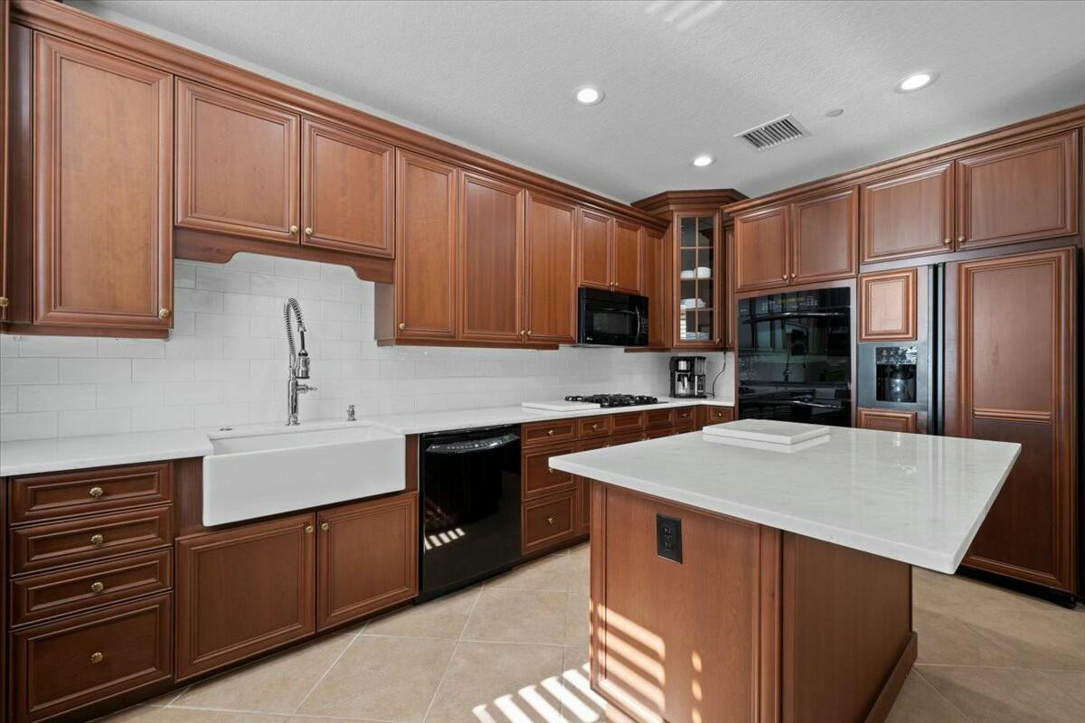 222 Tresana Boulevard, Unit 44 Jupiter, FL 33478 - Photo 13 of 63 a kitchen with stainless steel appliances granite countertop a refrigerator sink and cabinets