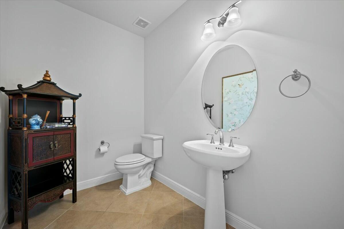 222 Tresana Boulevard, Unit 44 Jupiter, FL 33478 - Photo 15 of 63 a bathroom with a sink toilet and a mirror