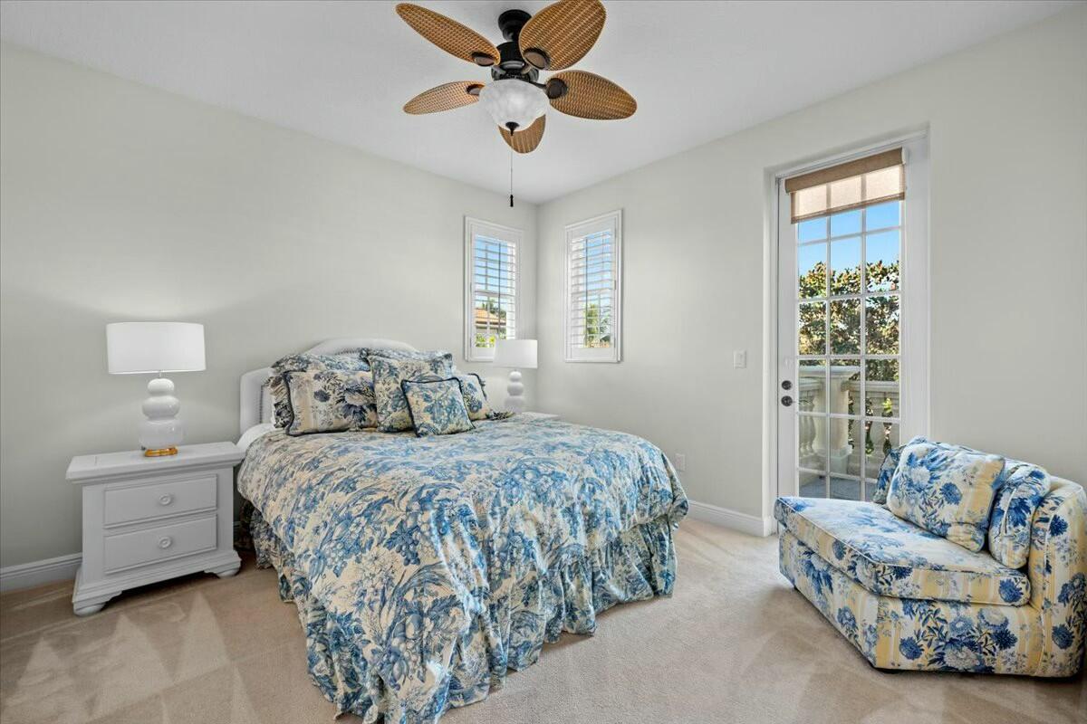 222 Tresana Boulevard, Unit 44 Jupiter, FL 33478 - Photo 22 of 63 a bedroom with a bed and a chandelier