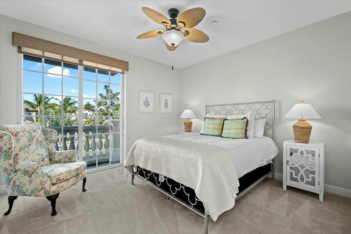 222 Tresana Boulevard, Unit 44 Jupiter, FL 33478 - Photo 23 of 63 a bedroom with a bed a chandelier and a couch