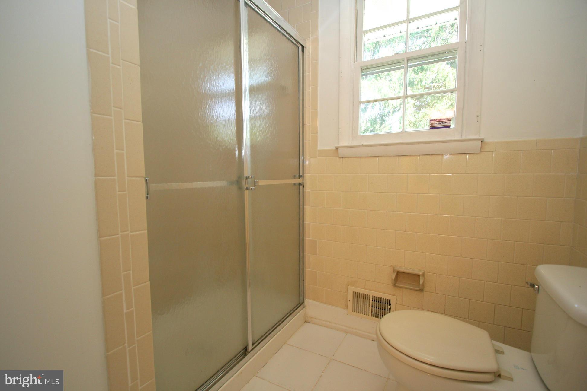 9429 Dartmouth Road Columbia, MD 21045 - Photo 13 of 27 a white toilet sitting next to a bathroom sink and vanity