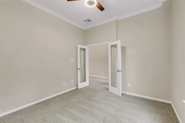 an empty room with chandelier fan