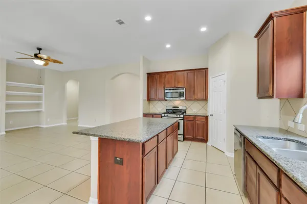 a kitchen with granite countertop a sink stove and cabinets